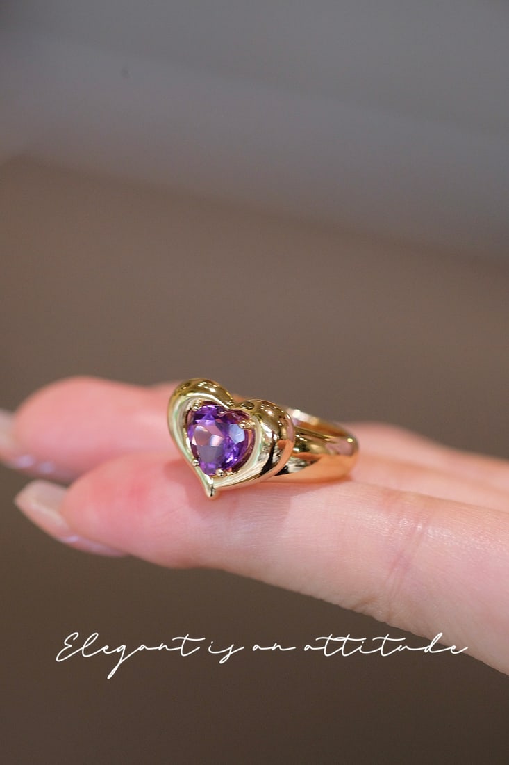 Amethyst Ring: Title: Amethyst Ring Description: This amethyst ring features a bright hue and a three-dimensional heart design, exuding a vintage charm. It pairs well with various outfits, subtly revealing an elegan