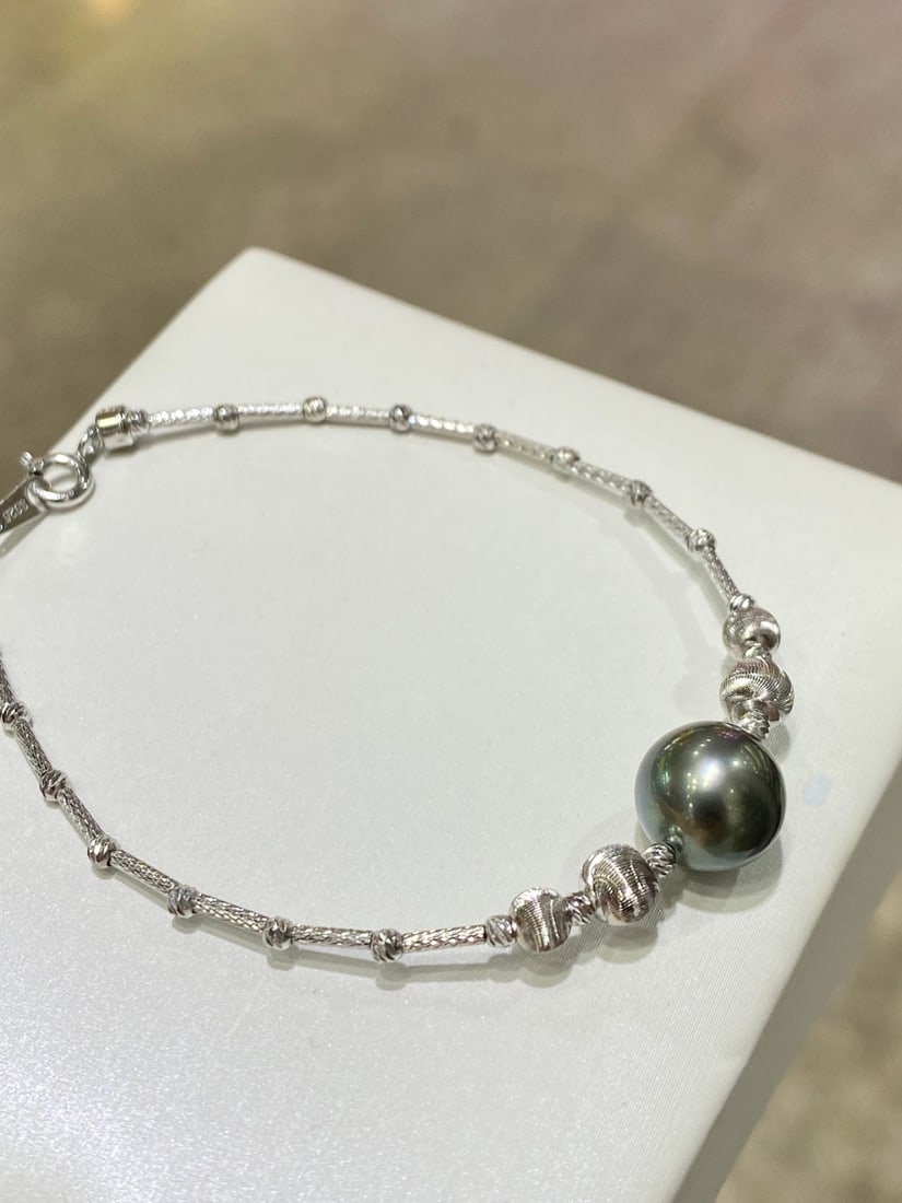 Sterling Silver Tahitian Black Pearl Bracelet: Title: Sterling Silver Tahitian Black Pearl Bracelet Description: This bracelet is meticulously crafted from sterling silver, featuring Tahitian black pearls that exude an elegant aura. The pearls'