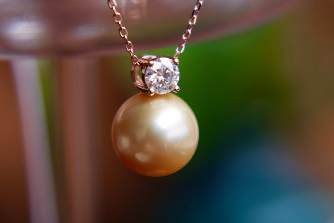 18K Gold Saltwater Pearl Pendant: Title: 18K Gold Saltwater Pearl Pendant Description: This pendant is meticulously set in 18K gold, featuring a 12.03mm saltwater pearl. The pearl is perfectly flawless and round, exuding a captivating