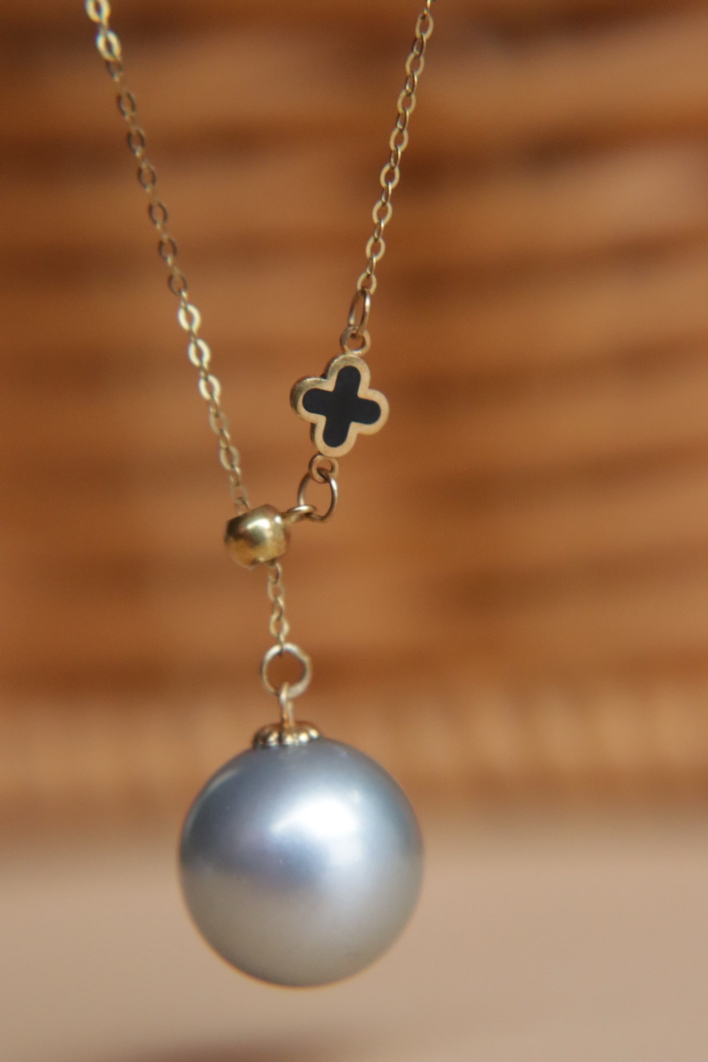 18K Gold Tahitian Gray Pearl Pendant: Title: 18K Gold Tahitian Gray Pearl Pendant Description: This pendant features an 18K gold base paired with a Tahitian gray pearl. The pearl measures 11mm in diameter, showcasing a perfect round shape
