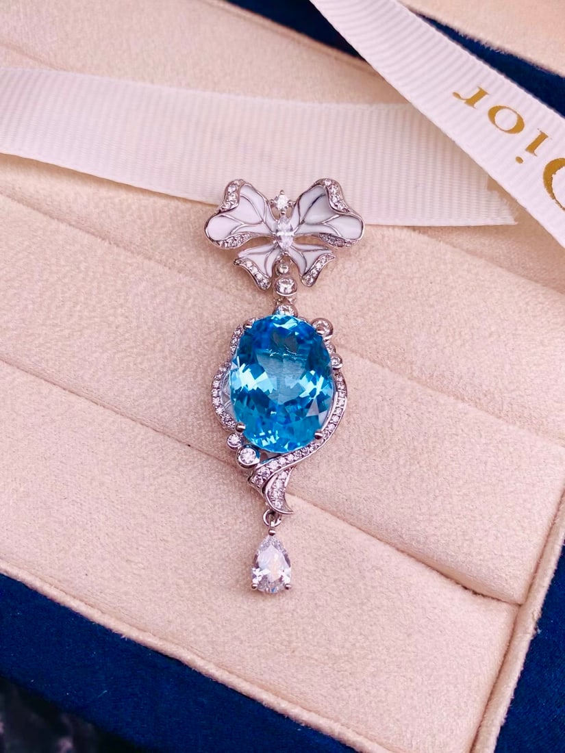 925 Silver Topaz Pendant: Title: 925 Silver Topaz Pendant Description: This pendant is crafted from 925 silver, set with topaz, showcasing an elegant brilliance. The enamel bow design adds a lively touch. Main stone size is