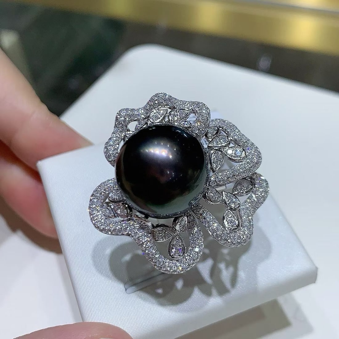 Thick Silver Slightly Flawed Black Pearl Ring: Title: Thick Silver Slightly Flawed Black Pearl Ring Description: This ring features a thick silver base set with a slightly flawed black pearl. The pearl exhibits a subtle green sheen, adding a