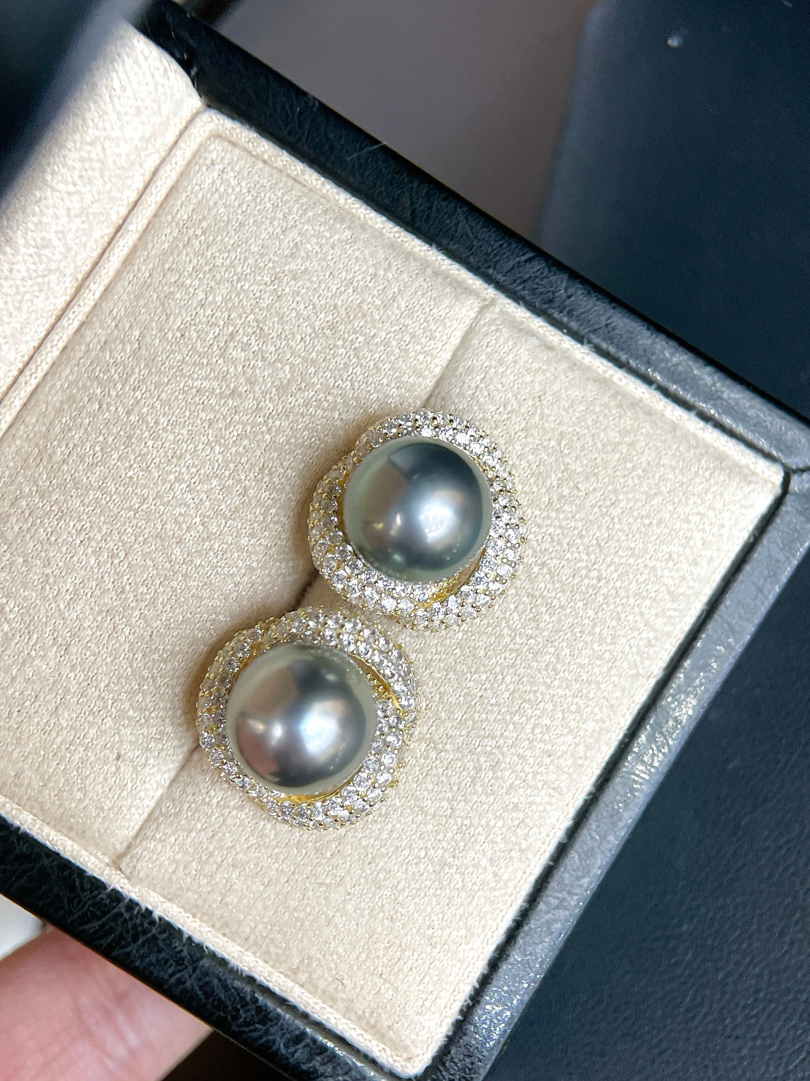 Tahitian Pearl Earrings: Title: Tahitian Pearl Earrings Description: These earrings showcase the unique charm of Tahitian pearls, with a lustrous sheen and slight blemishes. Paired with zircon, they sparkle under the light, e
