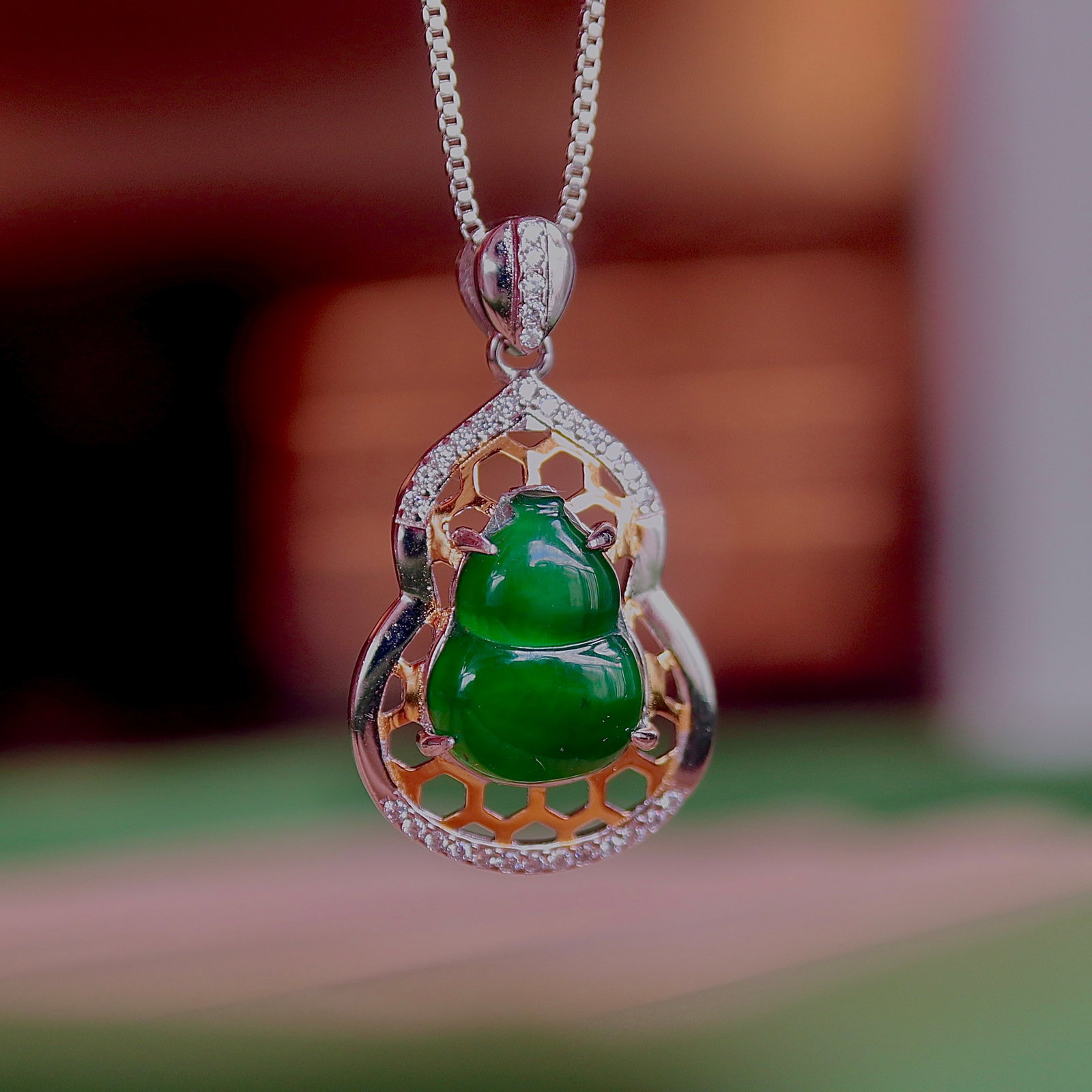 S925 Silver Natural Jade Gourd Pendant: Title: S925 Silver Natural Jade Gourd Pendant Description: This natural jade gourd pendant is set in S925 silver, showcasing a simple and elegant design. The hollow two-tone border adds a unique