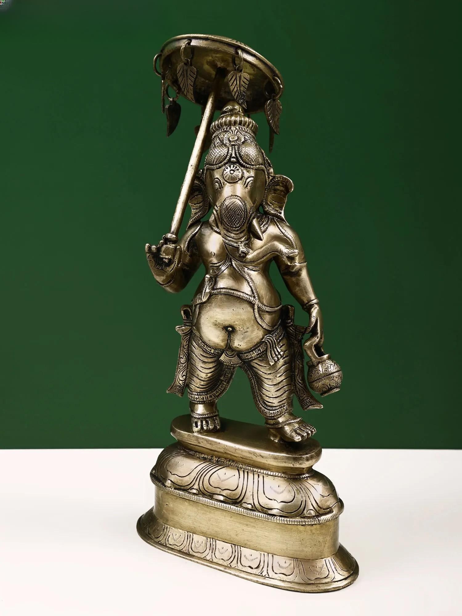 15" Brass Lord Ganesha Statue with Umbrella | Handmade | Made in India: Description: See It In Your Home "Obstacles do not block the path; they are the path." - Zen Proverb the Lord Ganesha with Umbrella, a masterpiece handmade in India, is more than a sculpture; it's a