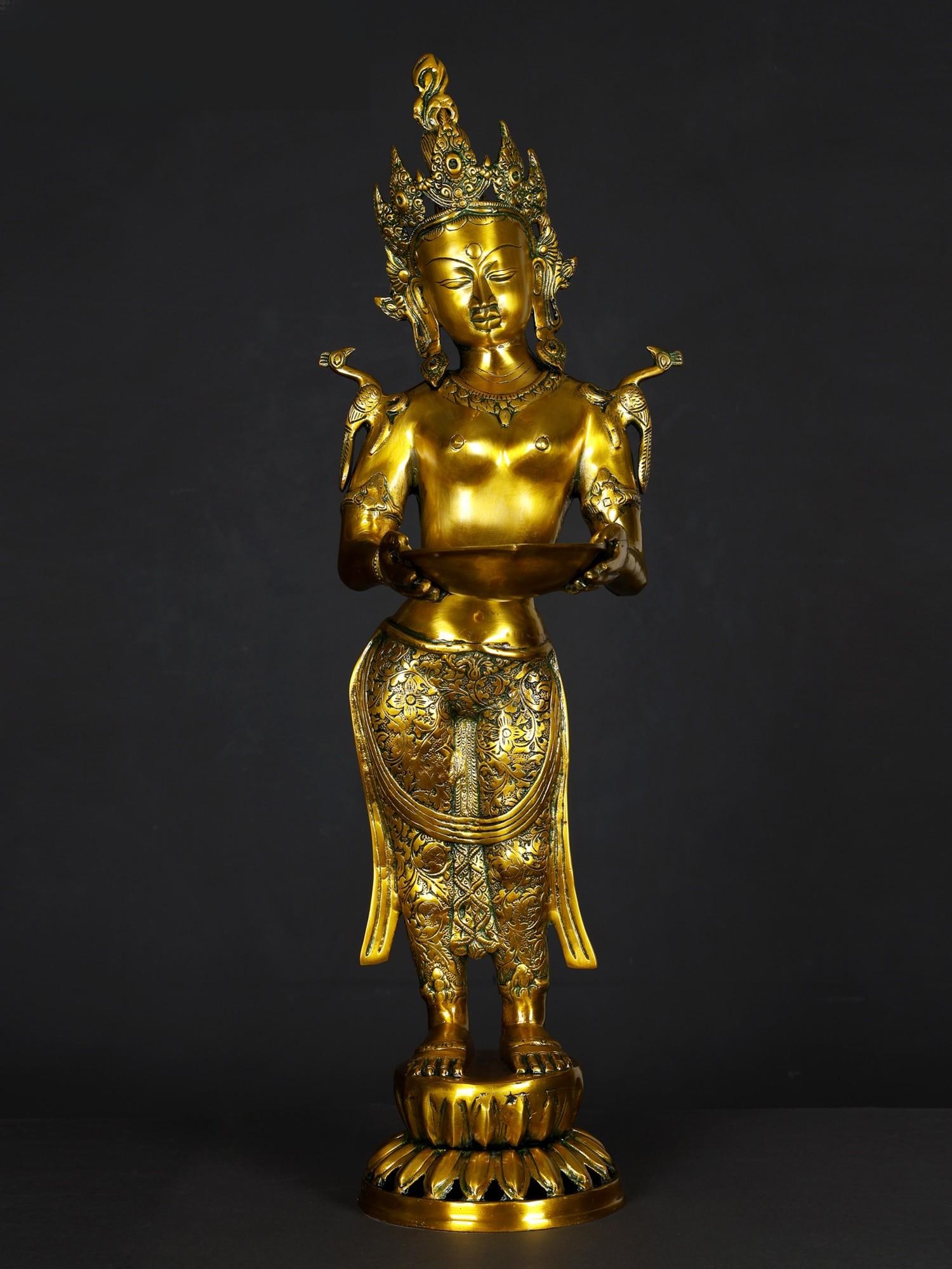 30" Tara with Lamp In Brass | Handmade | Made In India: Description: See It In Your Home Devi Tara in the welcoming stance. She bears in Her hands a lamp, shallow-bottomed with just one wick, yet enough to light up Her whole face and decolletage. Tara is a