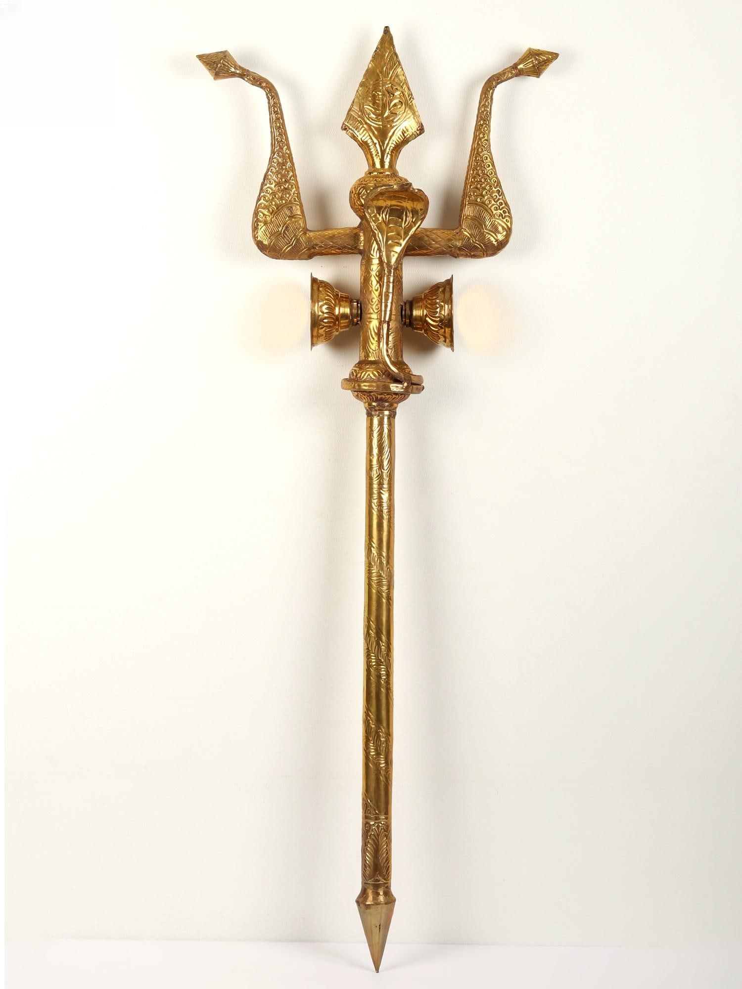 Snake Design Brass Trishul: Description: "In the serpent's embrace, wisdom unfolds." This Brass Trishul, adorned with intricately detailed snakes, weaves a tale of ancient wisdom. The serpent, often linked with Lord Shiva ,