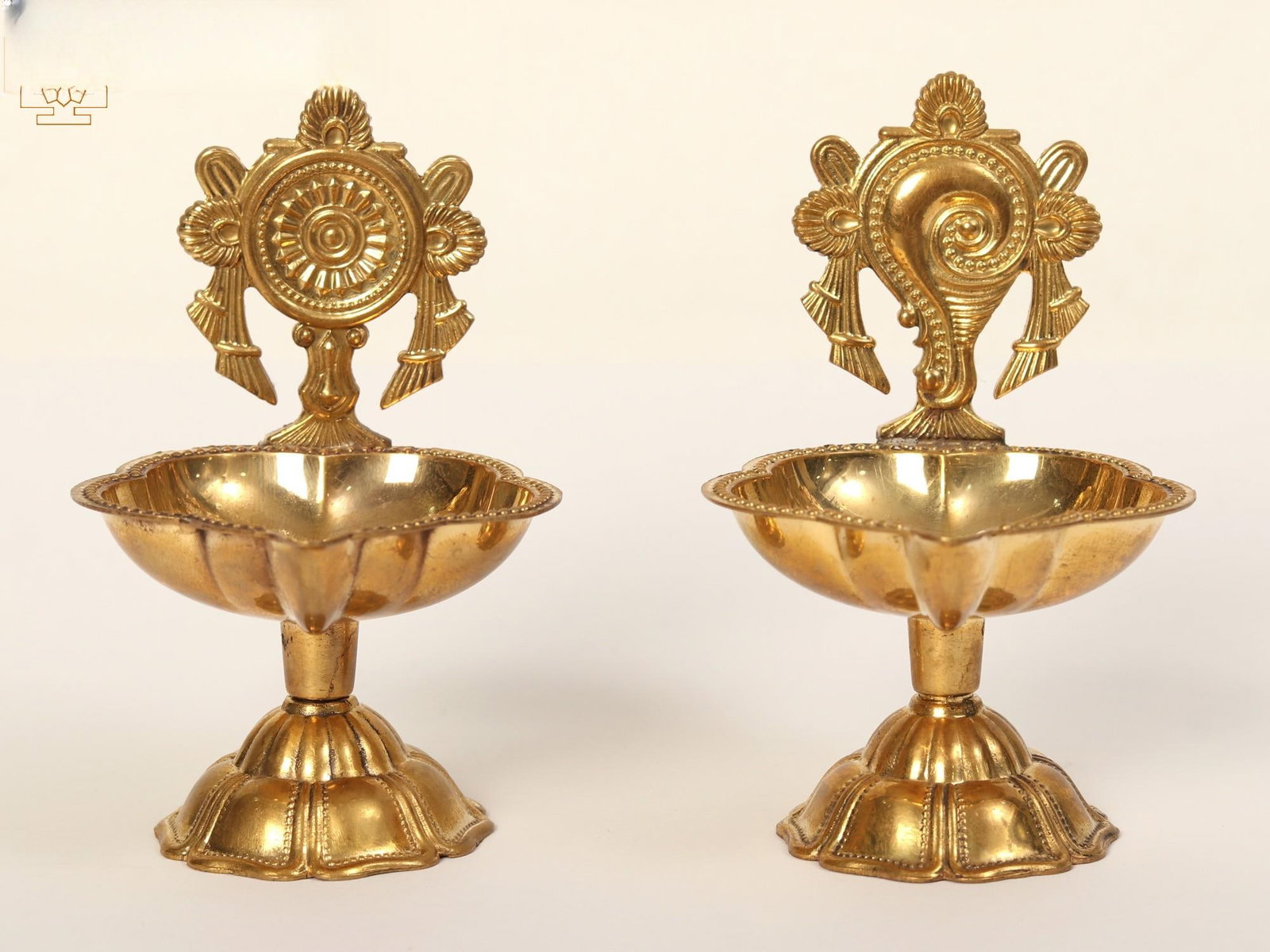 3" Small Pair of Shankh Chakra Oil Lamp: Description: This pair of brass lamps depicting the Vaishnava emblems of Panchajanya (conch) and Sudarshan Chakra (wheel) is a religious symbolism-rich piece of art. In Hinduism, Lord Tirupati, also