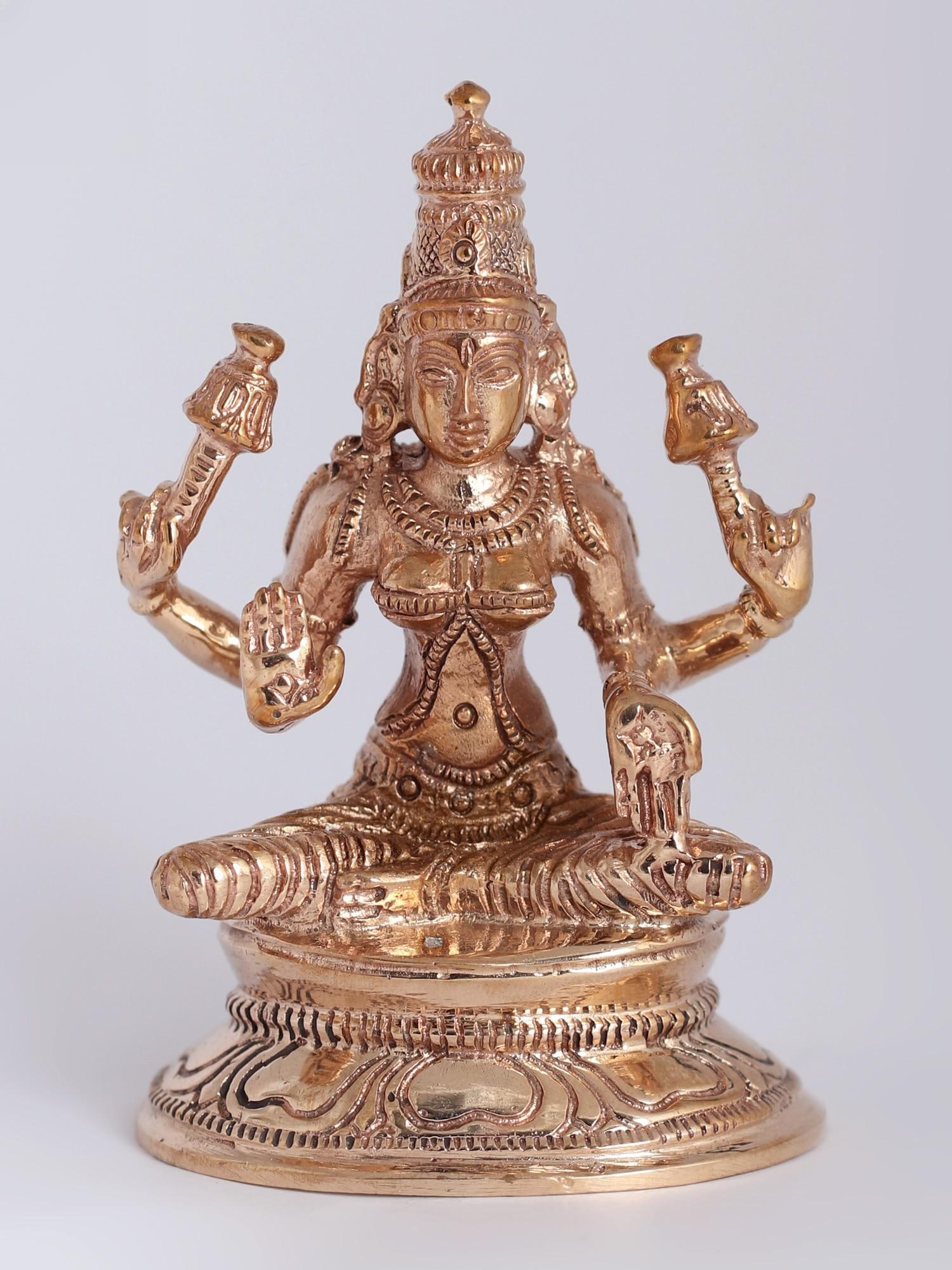 3" Bronze Goddess Lakshmi Statue Seated on Pedestal: Description: The Bronze Goddess Lakshmi , gracefully seated on a divine pedestal, embodies divine benevolence. Her chaturbhuja roopa, with four arms, radiates supreme auspiciousness. Adorned in