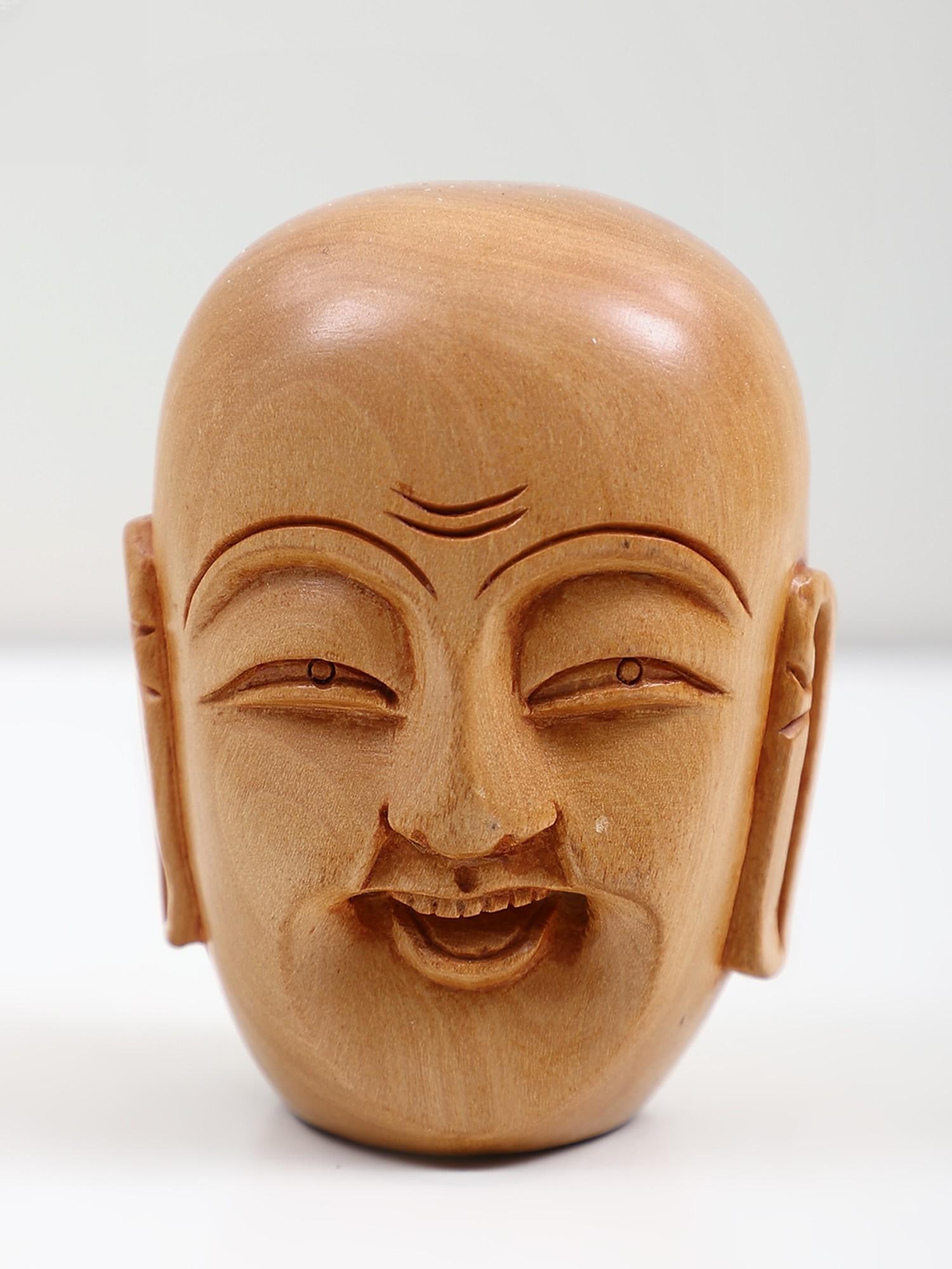 3" Small Wooden Laughing Buddha Head Idol: Description: The laughing Buddha head symbolizes joy, contentment, and abundance in Buddhist teachings. It represents the enlightened state of mind, where one finds inner peace and harmony regardless 