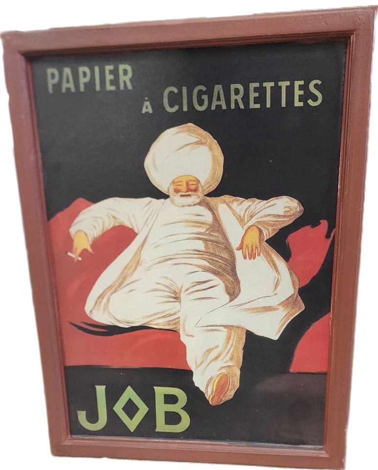 Lithograph replica of famous JOB cigarette paper advertising poster designed by Leonetto Cappiello.: This is a framed reproduction on board of the famous "JOB" cigarette paper advertising poster designed by Leonetto Cappiello in 1912. Leonetto Cappiello (1875–1942), known as the "father of mode