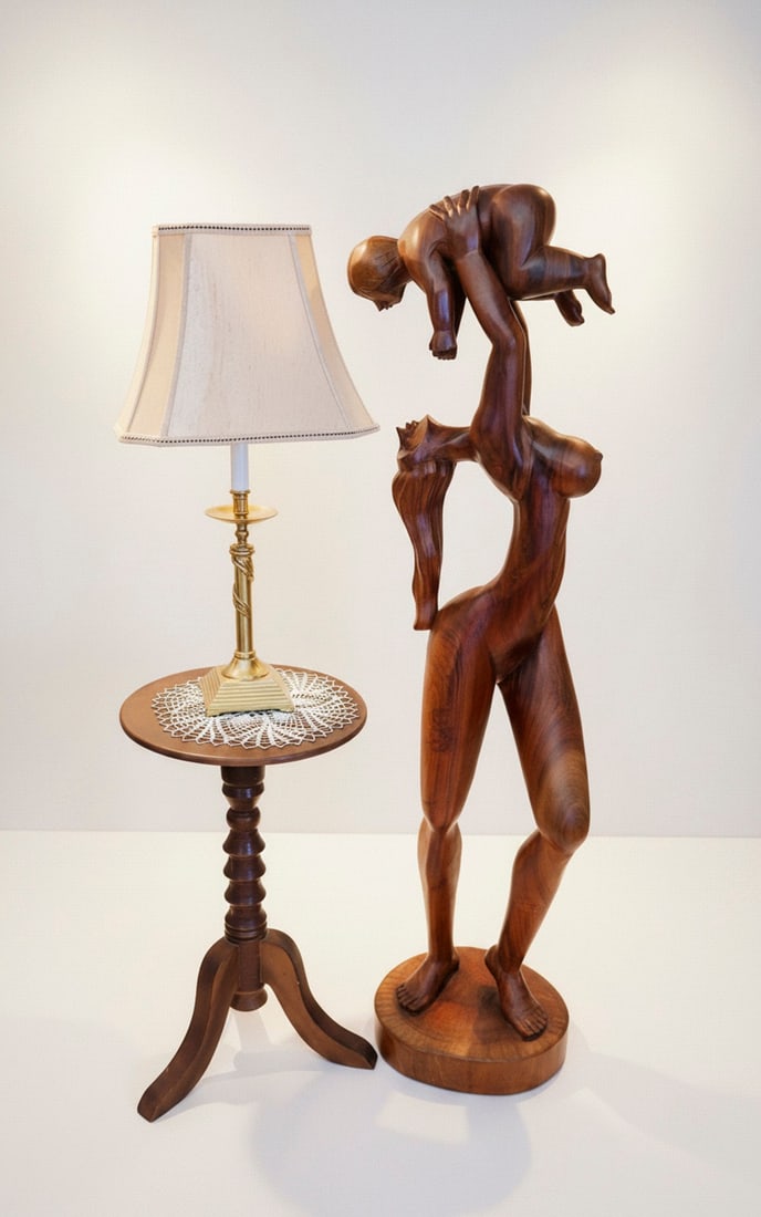 Large Carved Wood Mother and Child Sculpture-Ecuador: A substantial and beautifully carved wooden sculpture depicting a mother holding her child aloft. The rich, dark wood grain is prominent, and the figures are rendered with smooth, flowing lines, empha