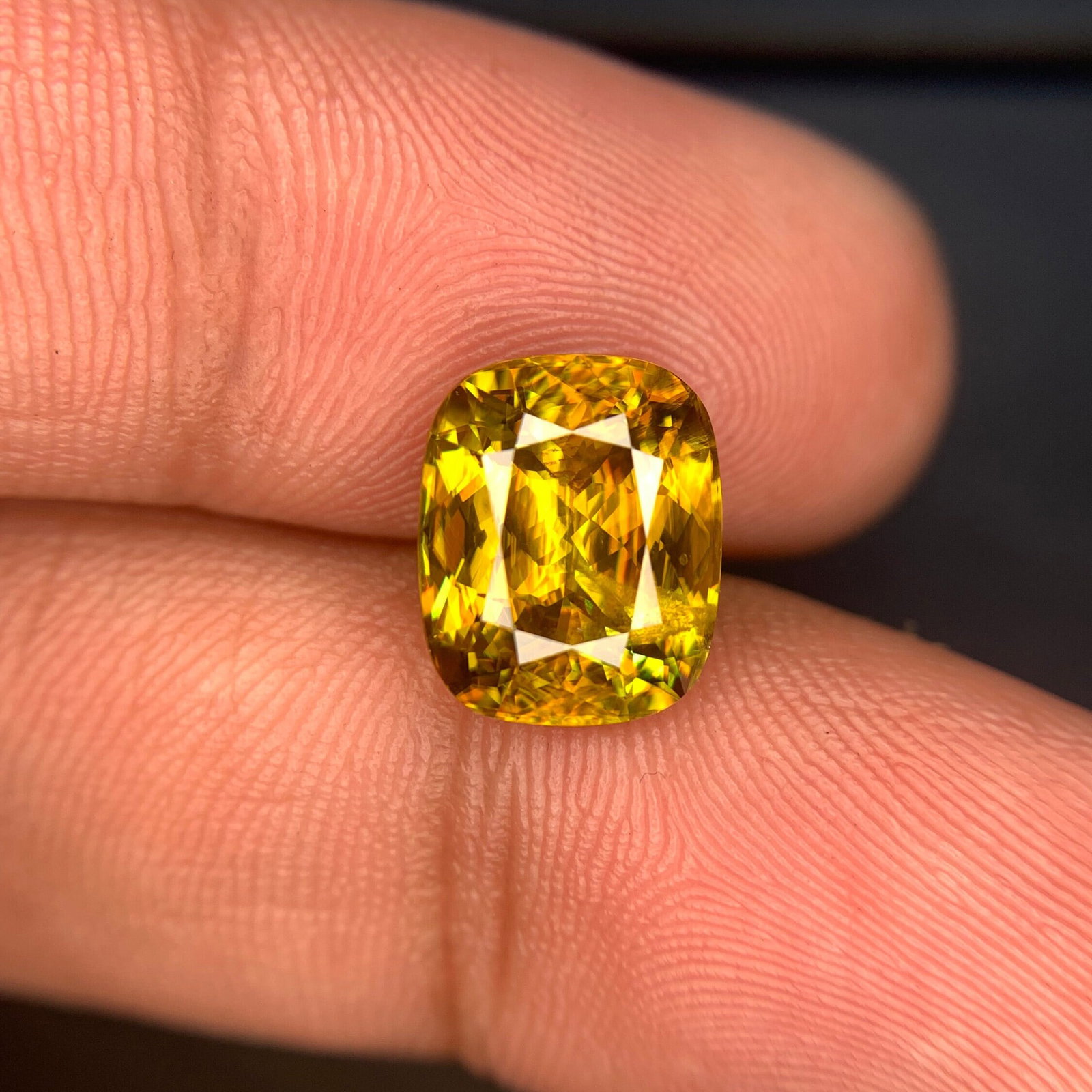 4.20 Carat Greenish Yellow Sphene Gemstone: Cushion Cut Titanite: This stunning full fire sphene titanite loose gemstone features a captivating cushion cut that enhances its brilliance and beauty. With its vibrant play of colors and exceptional clarity, this