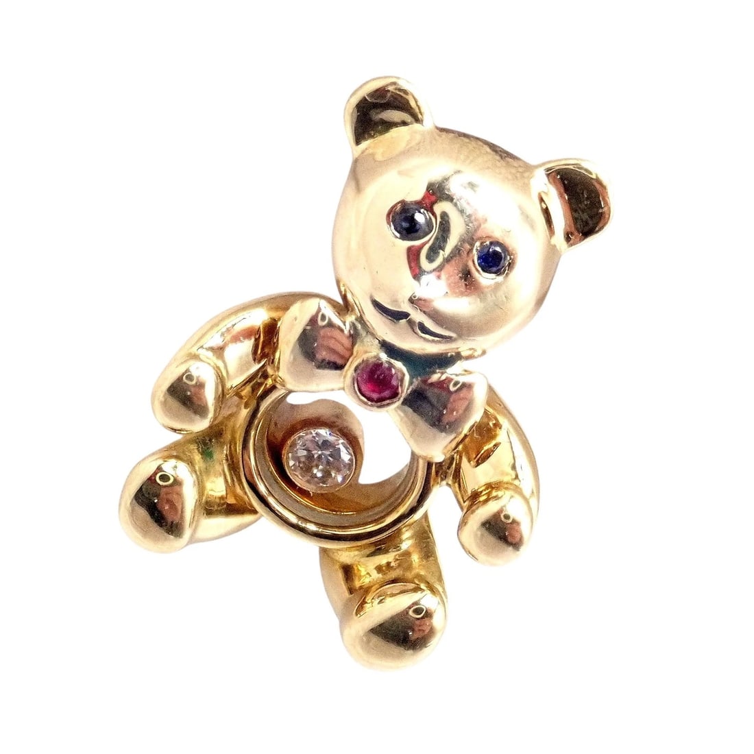 Chopard 18k Yellow Gold Teddy Bear Happy Diamond Ruby Sapphire Pin Brooch: This charming Chopard Teddy Bear Happy Diamond pin brooch is crafted in 18k yellow gold. Features a playful movable floating diamond at the center, ruby bow accent, and sapphire eyes. A delightful col