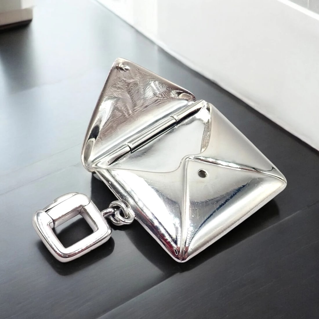 Rare! Louis Vuitton LV 18k White Gold Opening Envelope Letter Charm Pendant: The Louis Vuitton LV 18k White Gold Opening Envelope Letter Charm Pendant is a sophisticated, whimsical accessory. Crafted in polished 18k white gold, it features a envelope that opens to reveal space