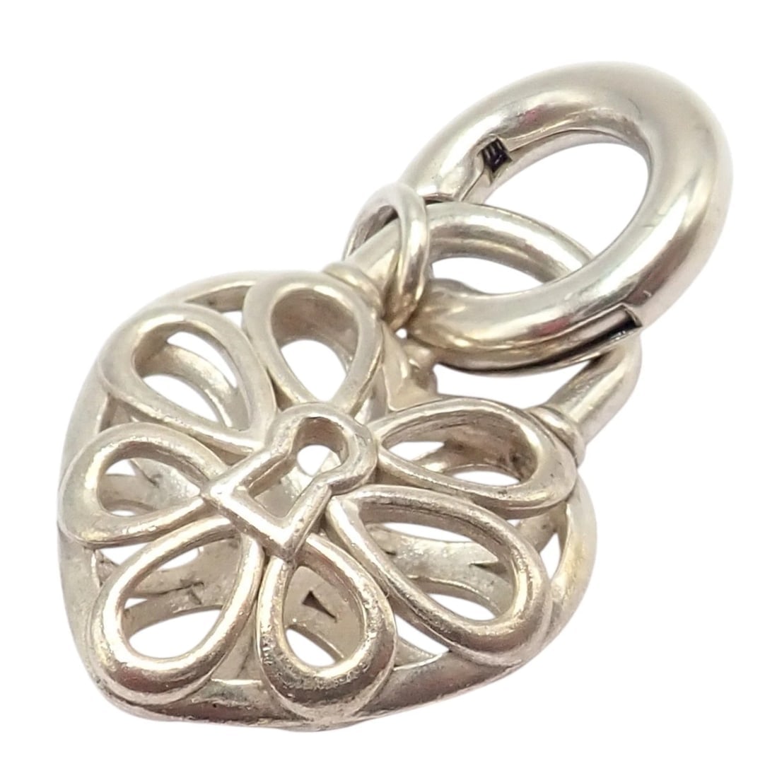 Tiffany & Co. Silver Heart Daisy Padlock Charm Pendant + Spring Ring Clasp: Tiffany & Co. Silver Heart Padlock Charm Pendant with Spring Ring Clasp — Crafted from gleaming sterling silver, this elegant charm features an openwork heart daisy design inspired by Tiffany