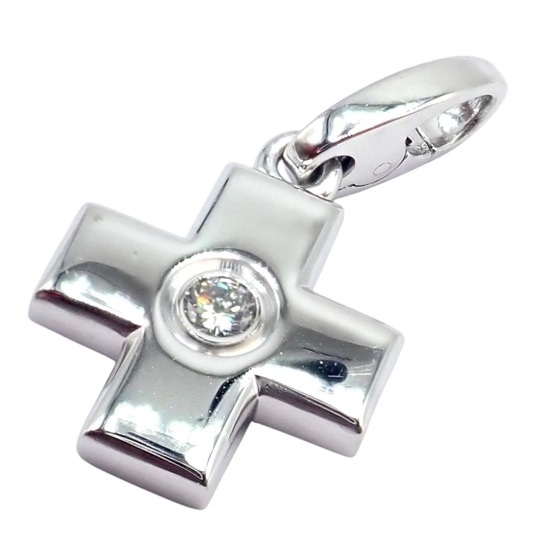 Authentic! Cartier 18k White Gold Diamond Small Cross Charm Pendant: Cartier 18k white gold small cross charm pendant features a sleek, polished silhouette with softly rounded edges. A single bezel-set diamond sparkles at the center, adding refined brilliance. Suspende