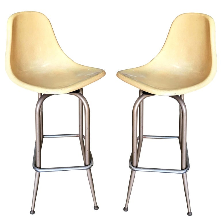 Midcentury Fiberglass Shell Swivel Bar Stool, Pair: This pair of vintage midcentury fiberglass shell seat swivel bar stools feature a retro charm. The bucket seats are made of durable fiberglass, exuding classic elegance. The chrome steel base ensures