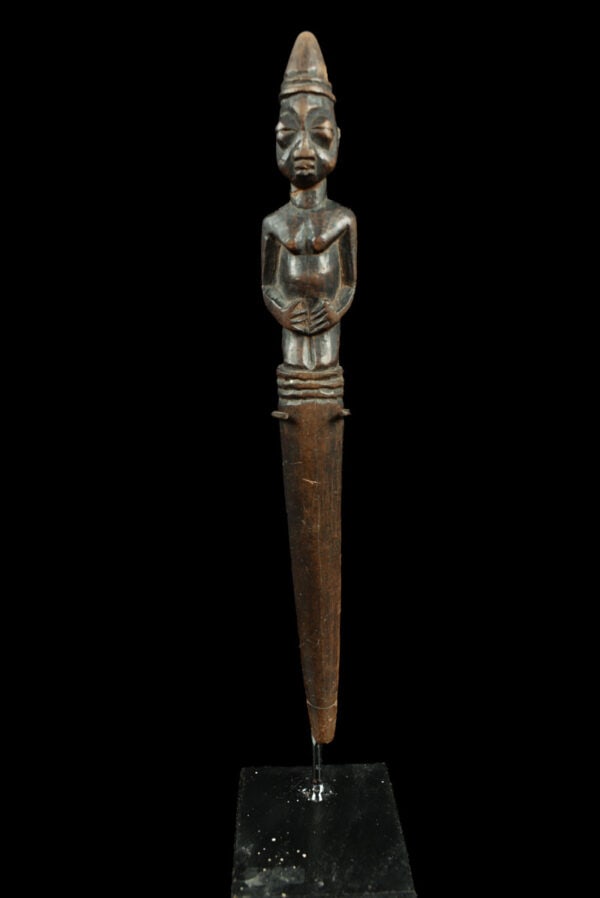 Pointer - Wood - Ifa Oracle - Yoruba - Nigeria: Iroke ifa pointer made of light wood for the IFA oracle, carved with a kneeling female figure, clutching her breasts, on the head the bell for summoning the Orishas; the handle (or pointer). Good