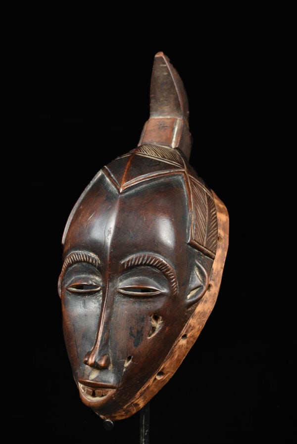 Dance mask - Wood - Yaure - Ivory Coast: Stunning dance mask with the typical Yaure style. The mask has a nice aged patina and fine cutting details. With signs of use and a beautiful aged patina. A real serene beauty! Object: Mask