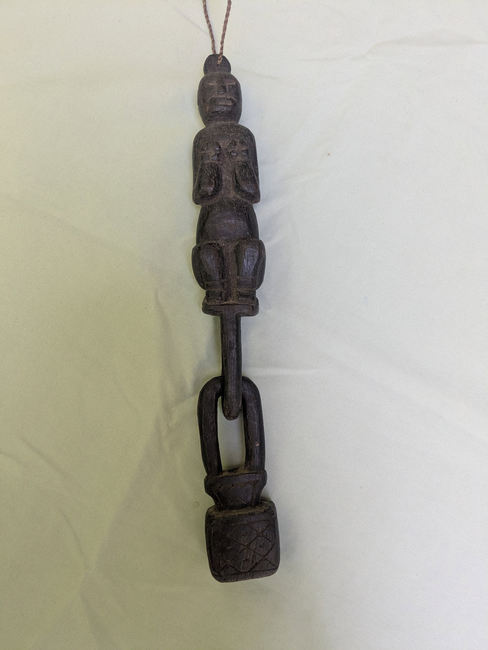 Squating Spirit Figure with Chain: Title: Squating Spirit Figure with Chain Description: This 'Hampatong" carving is from the Dayak people of Borneo, Indonesia. These small figures carved from durable ironwood, are designed to provide