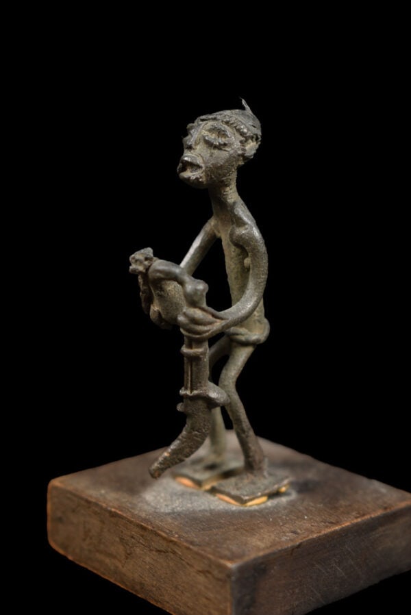 Goldweight figure - Bronze - Ashanti - Ghana: Beautiful bronze goldweight figure, who is probably cleaning it`s riffle, from the Ashanti people of Ghana. Provenance: former private collection from Germany. Including custom made stand. Object: