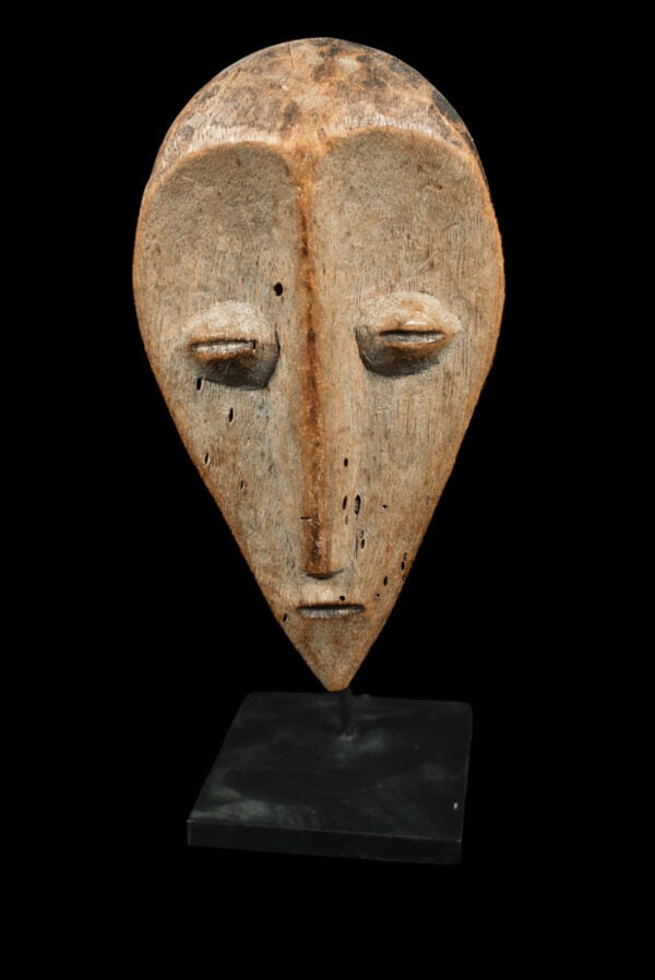 Mask - Wood - Lega - Congo: Lovely Lega Mask from Zaire or Congo. Wood with multi-layered patina. Remains of offerings, mica powder, kaolin. Condition: good with a beautiful aged patina due to tribal use. Covered in Pembe, white