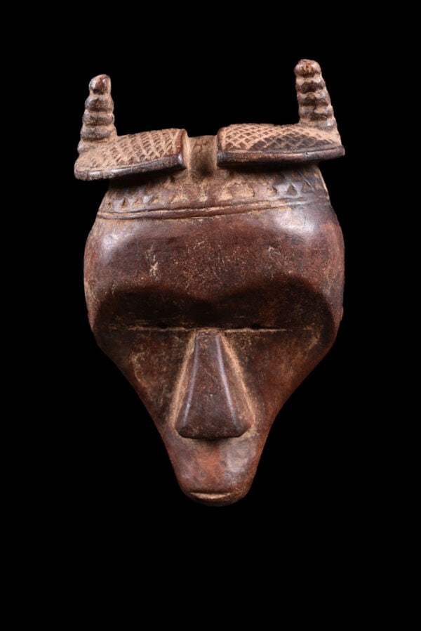 Passport Mask - Wood - Toma - Guinea: Powerful passport Toma mask from Guinea. The Toma mask hand-carved in West Africa, exemplifies the artistic skill of the Toma people. This sculpture, intricately detailed and adorned, serves as a