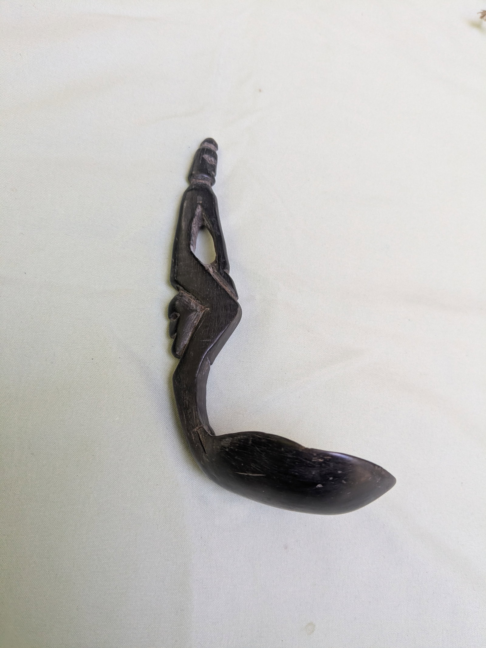 Buffalo Horn Spoon: Title: Buffalo Horn Spoon Description: This finely crafted unique water buffalo horn spoon from Indonesia features spirit figures carved on the handle. Date/Period: Collected 1985 Materials: Water Buf