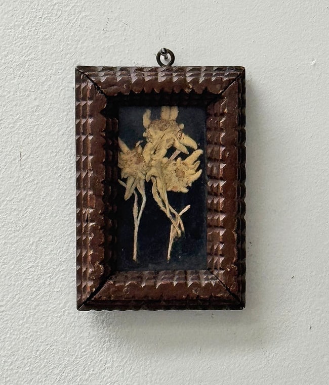 Tramp Art Frame with Dried Flowers Circa 1890s: All original tramp art frame with encased dried flowers. With its original glass and painted surface. In very good condition with no losses or repairs. Circa 1890s. Dimensions: 5.5" h x 3.75" w.