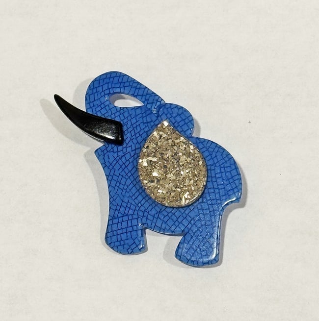 Lea Stein Signed Elephant Brooch: A signed Lea Stein Sacha blue elephant brooch by French designer Lea Stein who along with her husband, Fernand, developed an innovative technique of layering thin cellulose sheets and then laminating