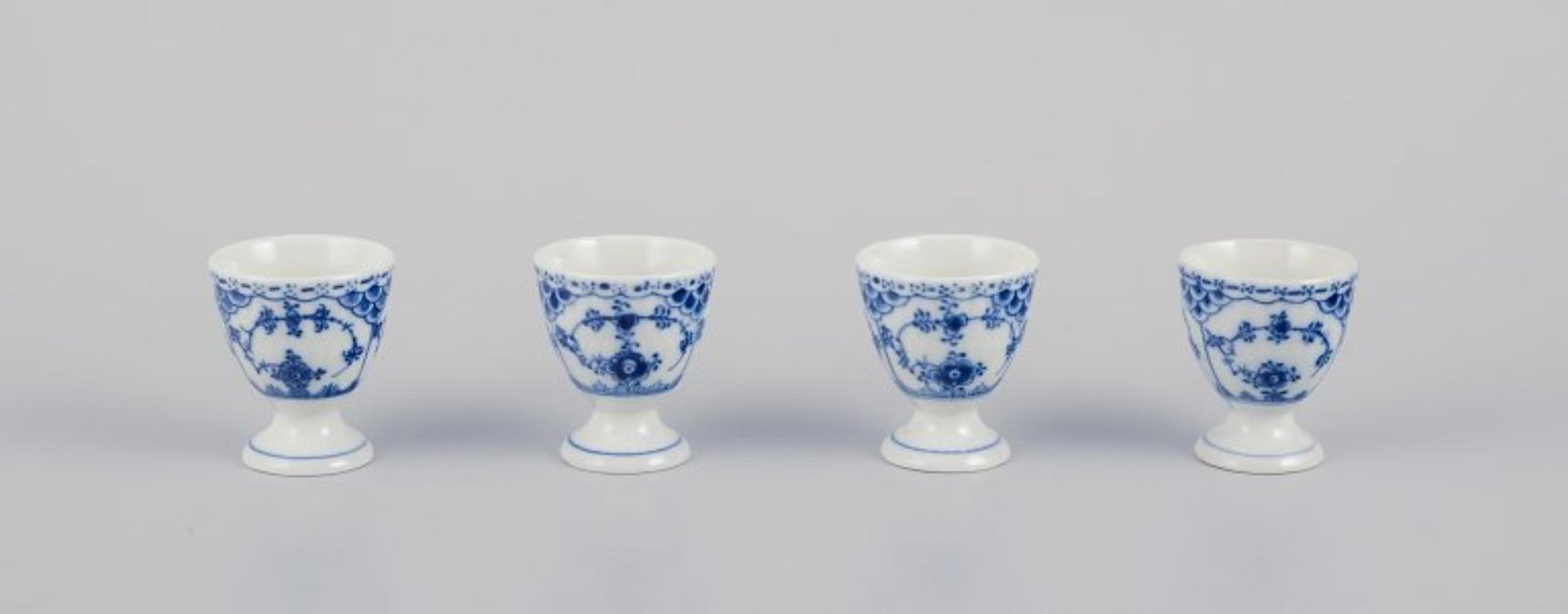 Royal Copenhagen Blue Fluted Half Lace, a set of four egg cups. Ca 1930: Royal Copenhagen Blue Fluted Half Lace, a set of four egg cups. Model number: 1/542. Dating: Ca. 1930. Marked. In perfect condition. Second factory quality. Dimensions: H 6.0 cm x D 5.0 cm. Reserve: $