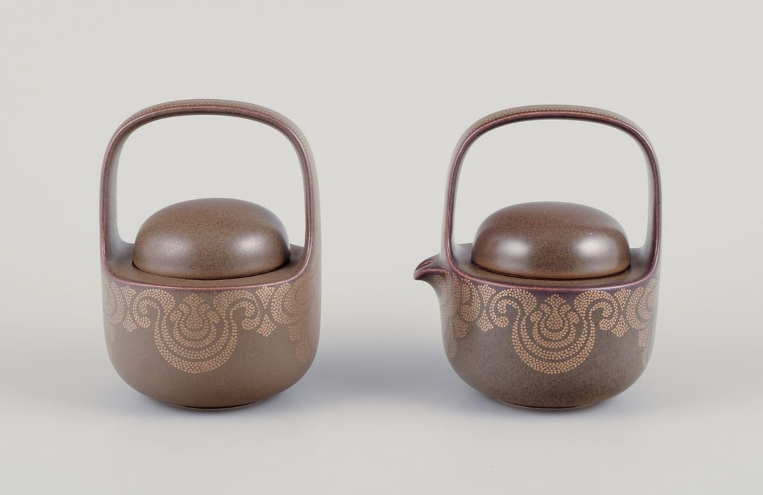 Timo Sarpaneva for Rosenthal. "Kaari" porcelain creamer and sugar bowl. 1980s.: Timo Sarpaneva for Rosenthal. "Kaari" porcelain creamer and sugar bowl. Brown glaze with gold decoration. 1980s. Marked. In perfect condition. Appears as new. Creamer: H 13.0 cm x D 10.0 cm. Sugar