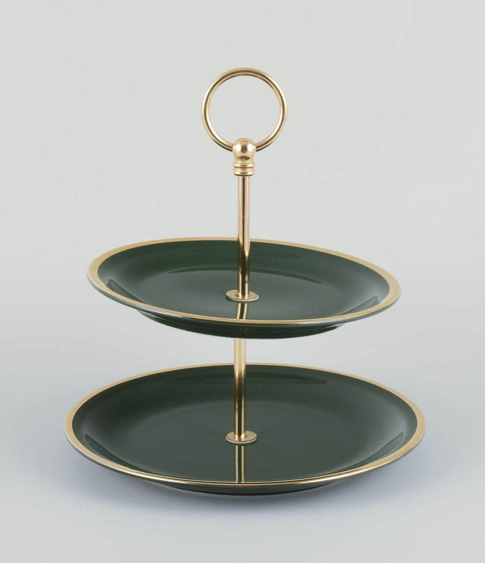 Pillivuyt, France. Cake stand/etagere in porcelain. Brass handle."Green Bistro". Ca. 1970s: Pillivuyt, France. Cake stand/etageƒe¨re in porcelain. "Green Bistro". Dark green glaze with gold decoration. Brass handle. Circa 1970s. Marked. Perfect condition. Dimensions: Diameter 23.0 cm. x