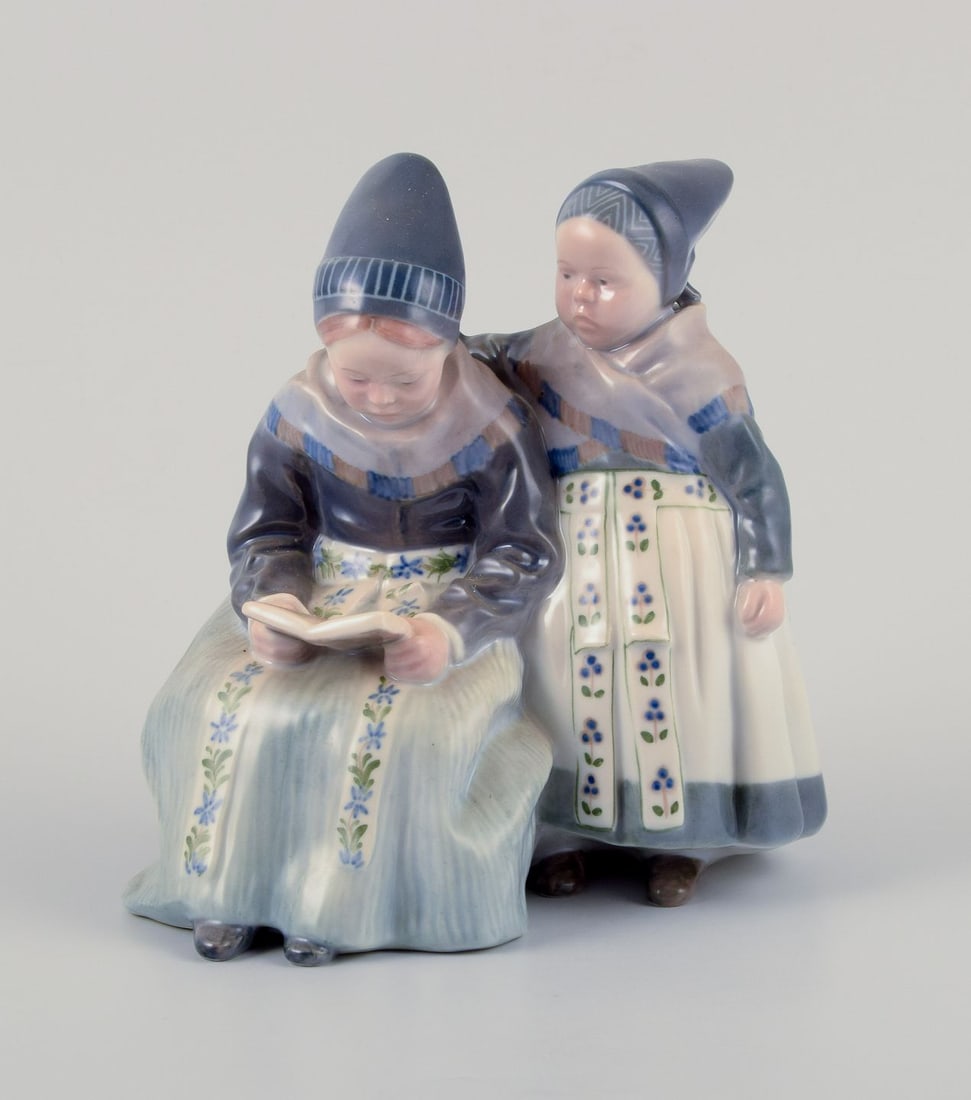 Royal Copenhagen figurine in porcelain. Two "Amager" girls in regional costume. Dated 1956: Royal Copenhagen figurine in porcelain. Two "Amager" girls in regional costume. Dating: 1956 Model number 1395. Marked. Second factory quality. Perfect condition. Dimensions: Width 17,0 cm. x Height