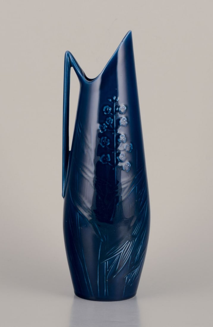 Rörstrand, large pitcher in porcelain. Floral motifs. Blue glaze.: Rörstrand, large pitcher in porcelain. Floral motifs. Blue glaze. Handmade. In perfect condition. Marked. First factory quality. Dimensions: Height 29.0 cm x Diameter 9.0 cm. Reserve: $224.00