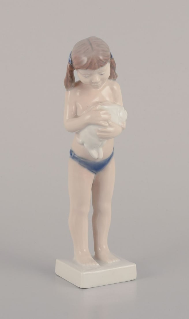 Royal Copenhagen porcelain figurine of a girl with a rabbit. 1980-1984.: Royal Copenhagen porcelain figurine of a girl with a rabbit. Designed by Sterett Kelsey. Model number: 5653. Dating: 1980-1984. In perfect condition. First factory quality. Dimensions: Height 18.0 cm