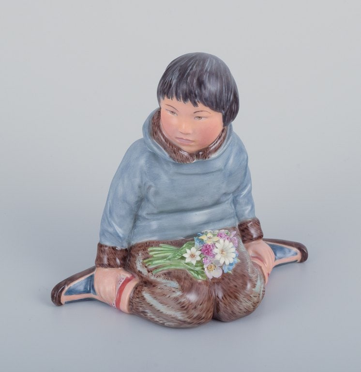 Royal Copenhagen, regional figurine of a Greenlandic boy holding a bouquet of flowers.: Royal Copenhagen, regional figurine of a Greenlandic boy holding a bouquet of flowers. Overglaze. Model: 12419. Juliane Marie mark. Approximately from the 1930s. In perfect condition. First factory qu