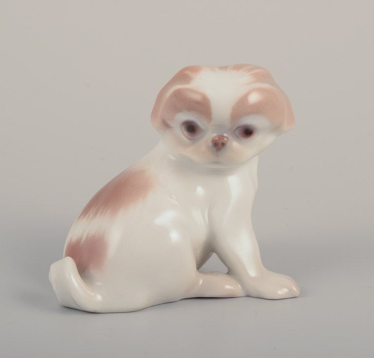 Bing & Grondahll, porcelain figurine of a Pekingese puppy.: Bing & Grondahll, porcelain figurine of a Pekingese puppy. Model 1987. Approximately from 1930. First factory quality. Perfect condition. Marked. Dimensions: L 6.0 cm x H 5.0 cm. Reserve: $252.00