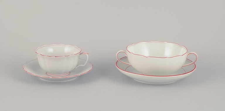 Meissen, Germany. Tea cup and bouillon cup with saucers. Decorated with coral red and gold-colored: Meissen, Germany. Tea cup and bouillon cup with saucers. Decorated with coral red and gold-colored trim. Art Deco. Approximately 1930s. Marked. Third factory quality. In beautiful condition with norma