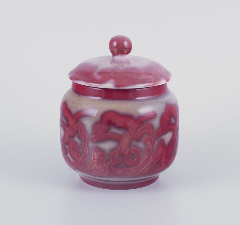 Edgar Bockman for Hoganas, Sweden. Lidded stoneware jar. Lustre glaze. Approximately 1940s.: Edgar Bockman (1890-1981) for Hoganas, Sweden, lidded stoneware jar. Lustre glaze. Wine red glaze on grey base. Approximately 1940s. Marked. in excellent condition. Dimensions: H 17.0 cm x 12.0 cm. Ed
