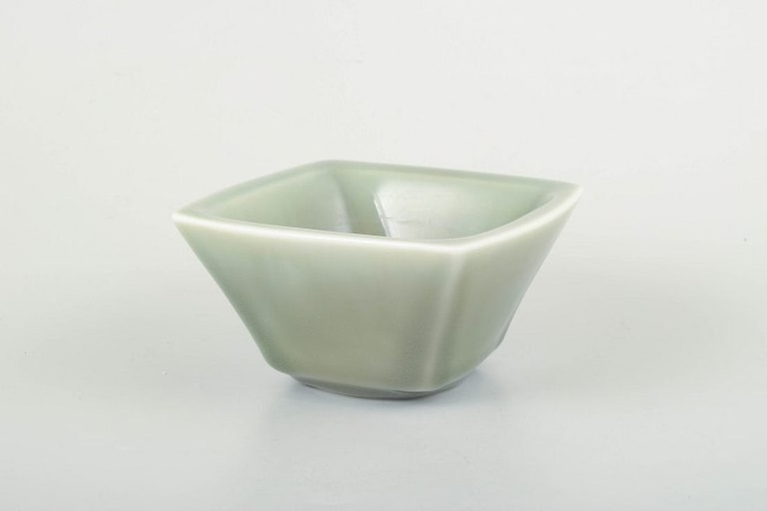 Nils Thorsson for Royal Copenhagen. Square ceramic bowl in green celadon glaze. 1950s-1960s.: Royal Copenhagen Square ceramic bowl in green celadon glaze. Designer: Nils Thorsson Model: 2876 Manufacturer: Royal Copenhagen, Denmark Material: Ceramic with celadon glaze Dimensions: H. 7.5 cm, D. 