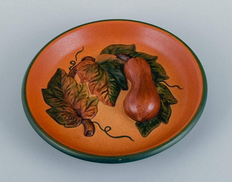 Ipsen's, Denmark. Bowl with leaves and pumpkins, glaze in shades of orange-green.: Ipsen's, Denmark. Bowl with leaves and pumpkins, glaze in shades of orange-green. Model 8. 1920s/30s. in excellent condition. Marked Dimensions: D 17.0 x H 3.0 cm. Reserve: $196.00 Shipping: Domestic: