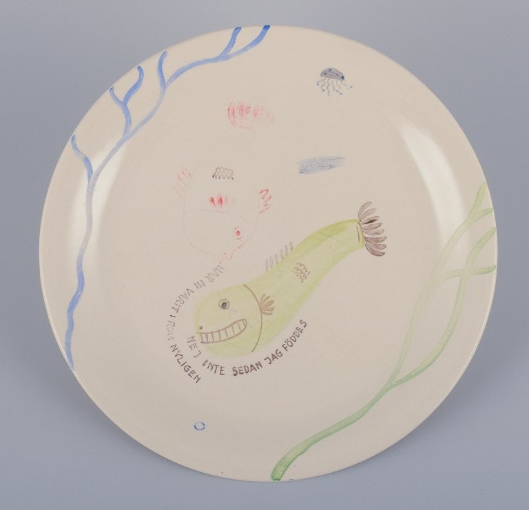Stig Lindberg for Gustavsberg. "Loja" plate. Hand-painted with a fish motif. Satirical illustration: Stig Lindberg for Gustavsberg. "Loja" plate. Hand-painted with a fish motif. Satirical illustration with Swedish text. From the 1950s. in good condition with minor wear to the paint. Marked. Dimension