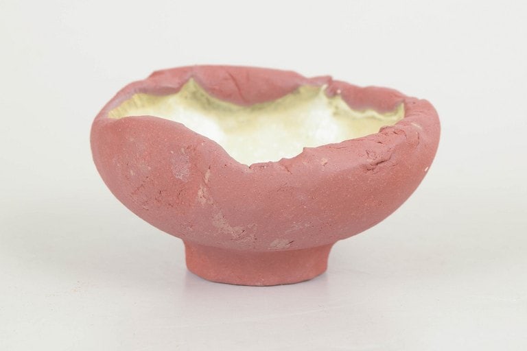 Christina Muff, Danish contemporary ceramicist (b. 1971). Tiny, one of a kind red stoneware bowl on: Christina Muff, Danish contemporary ceramicist (b. 1971). Tiny, one of a kind red stoneware bowl on foot. Unglazed on the outside the beautiful red clay contrasts the interior which is glazed in a cre