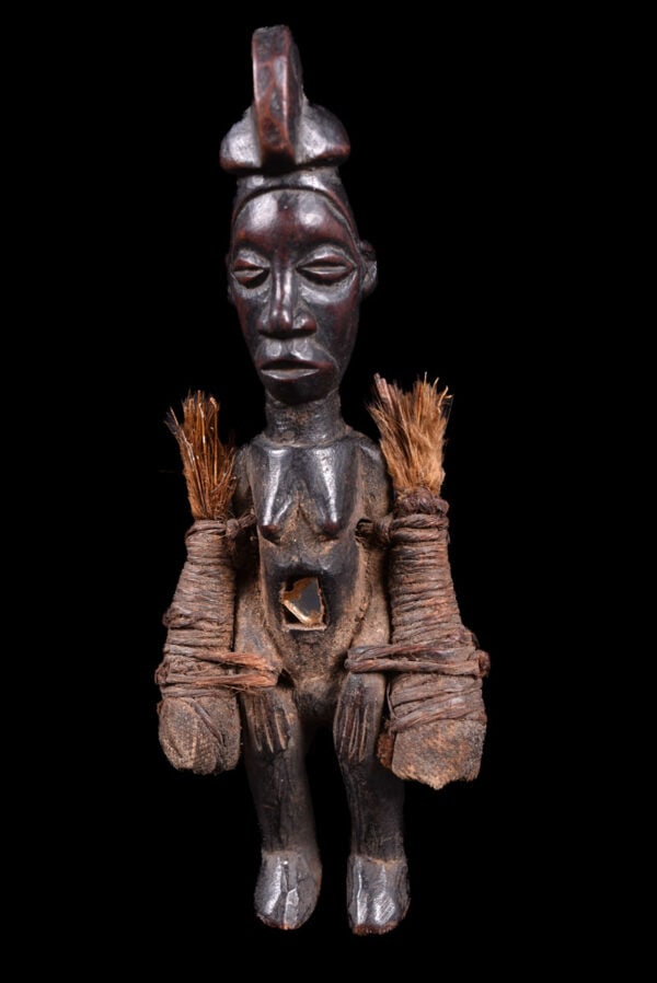 Fetish figure – Wood – Buti – Suku – Congo DRC: Powerfull Suku fetish figure from DR Congo. The majority of Suku figures were associated with Mbwoolo shrines. Their abdomen are hollow, enabling the insertion of fetish material and they are also