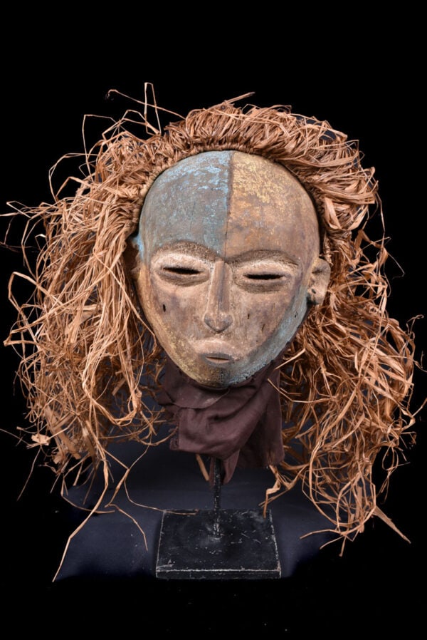 Helmet Mask – Wood, Raphia – Kwese – Gabon: Old wooden mask from the Kwese tribe of Gabon. The mask appeared during funeral ceremonies. Great use of blue and white pigments. Old aged patina. Contains clear traces of wear and tear due to aging