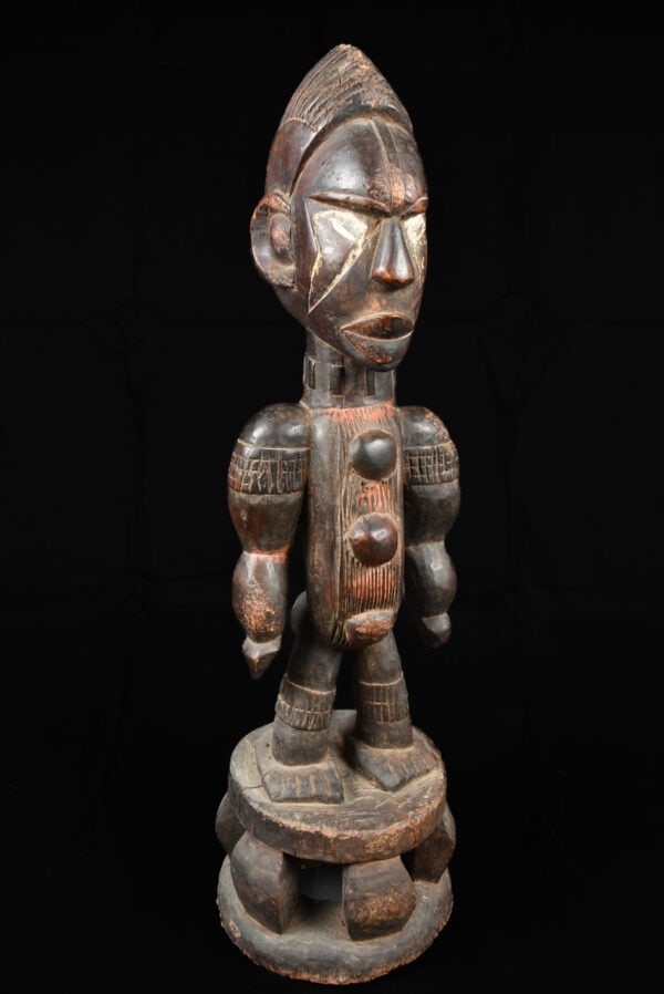 Shrine (figure) – Wood – Idoma – Nigeria: Large standing shrine figure from the Idoma people of NIGERIA. The wooden figure has a powerfull expression. Beautiful covered in whit phembe. Condition good with traces of tribal use. Total height: