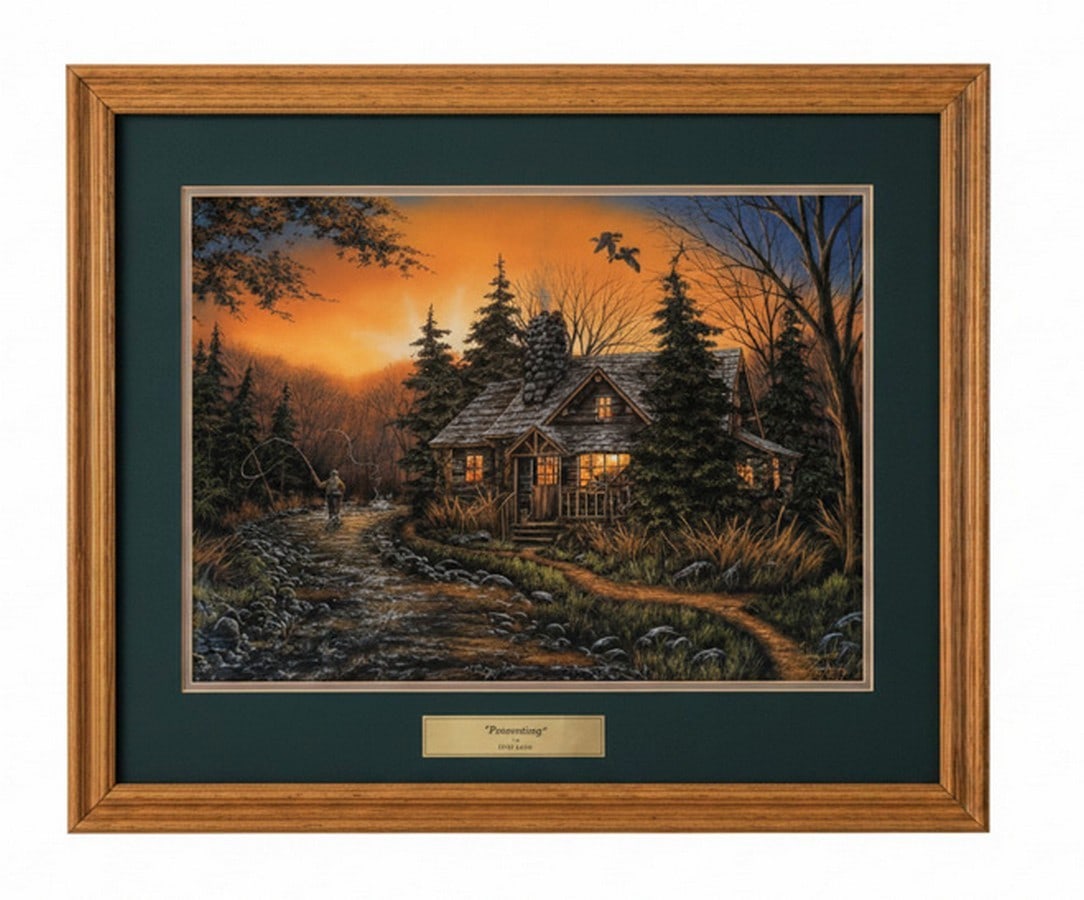 Gene Stocks "Primetime" Framed and Matted Print: A framed and matted print titled "Primetime" by artist Gene Stocks. The print depicts a rustic cabin nestled in a forest alongside a winding stream at sunset, with a fisherman in the distance. It is