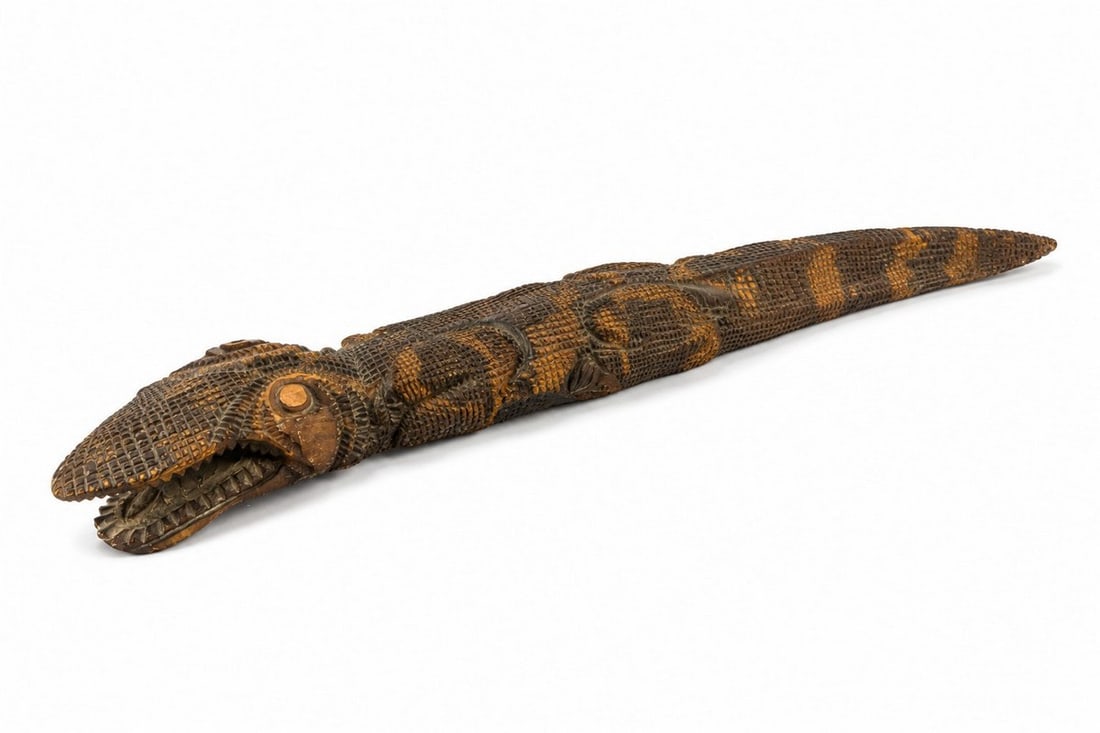 Vintage Carved Wood Crocodile: A vintage hand-carved wooden crocodile figure, featuring intricate scales and teeth details. The wood has a warm, aged patina with areas of lighter and darker tones, highlighting the carving work.